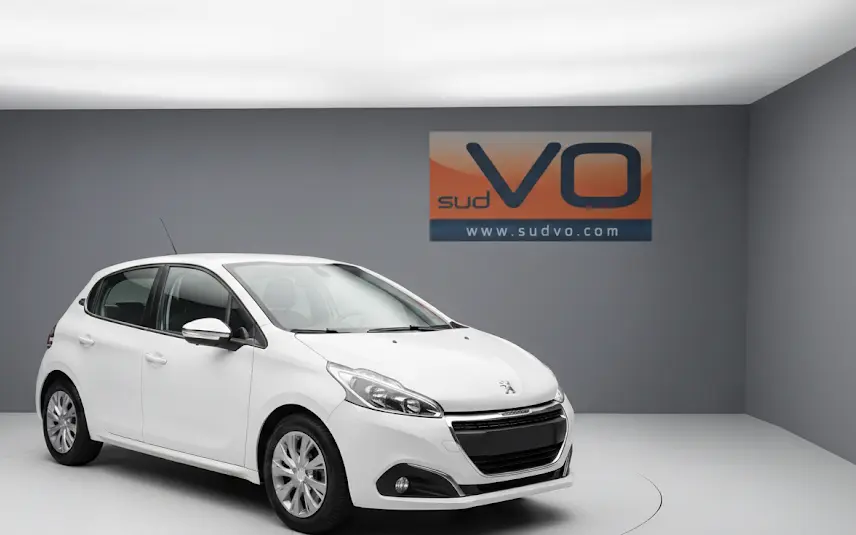 Peugeot 208 blanc vue 3/4 avant gauche dans un studio avec jantes classiques et phares antibrouillard visibles.