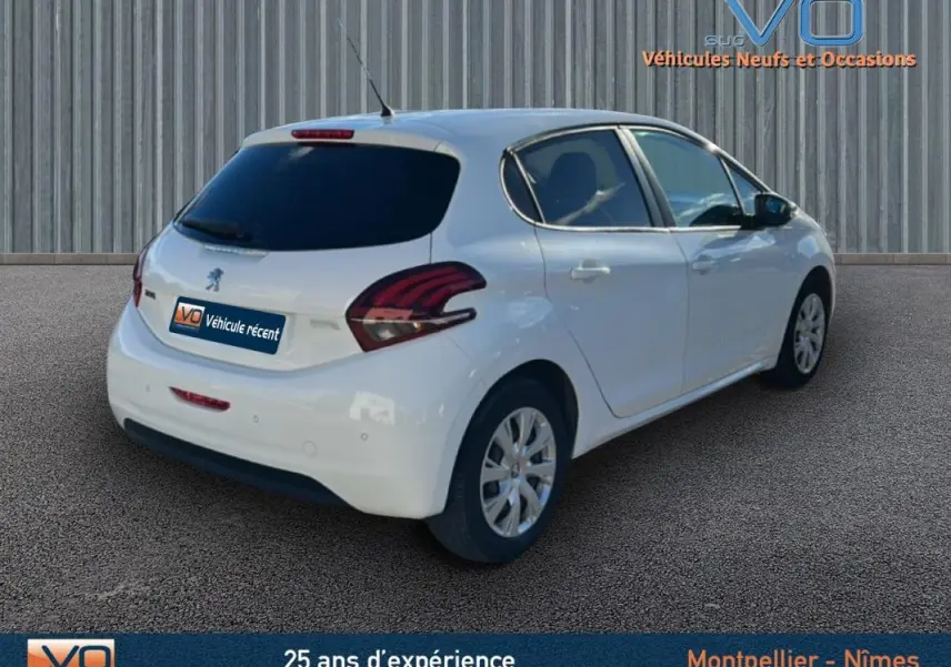 Vue 3/4 arrière droite d'une Peugeot 208 blanche de 2015 avec jantes classiques 15 pouces et vitres teintées arrière.