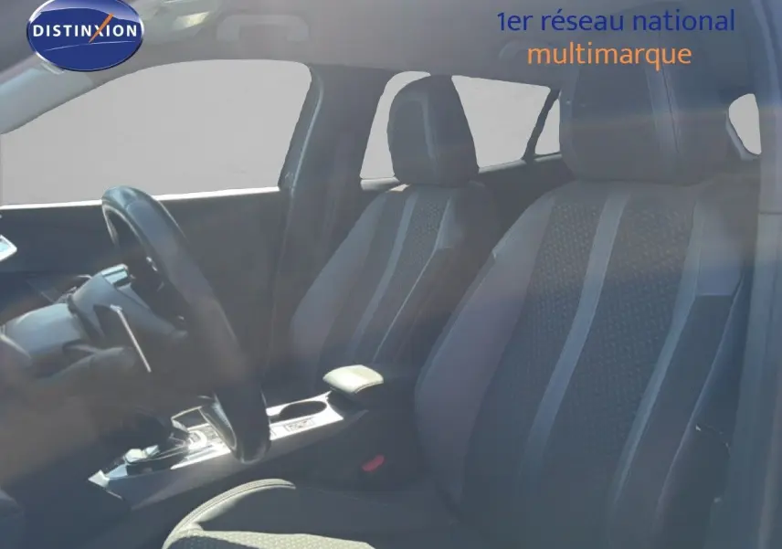 Vue intérieure avant du Peugeot 2008 gris platinium, mettant en valeur les sièges avant en tissu noir avec détails gris.