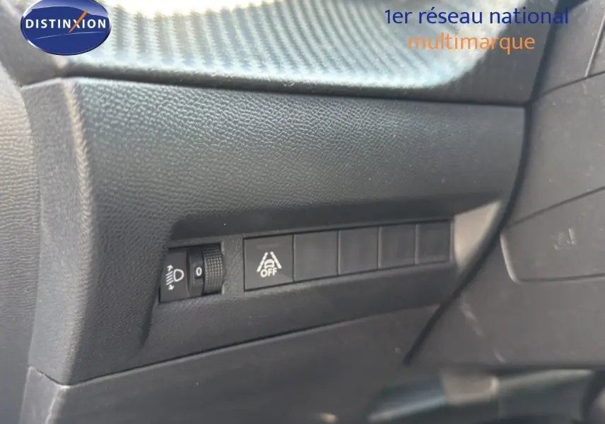 Vue rapprochée des commandes de réglage des phares et d'activation de l'alerte de franchissement de ligne dans un Peugeot 2008.