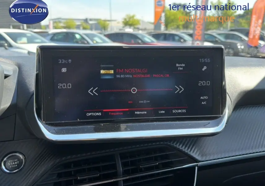 Vue rapprochée de l’écran tactile central du tableau de bord d’une Peugeot 2008 gris platinium, affichant la radio FM.