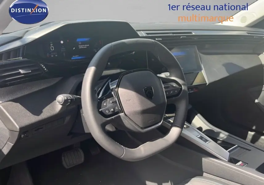 Vue intérieure du poste de conduite de la Peugeot 308 Hybrid 2025 en noir métal, avec volant multifonction et tableau de bord digital.
