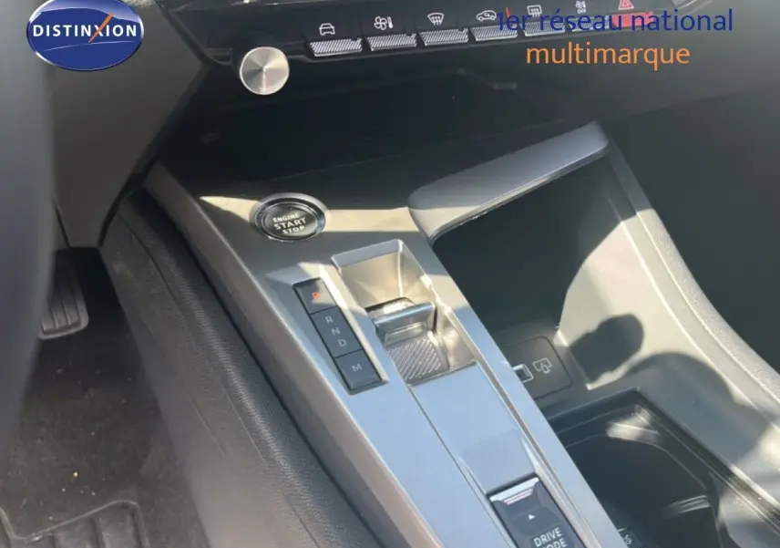 Gros plan sur la console centrale grise avec bouton start/stop et sélecteur de boîte automatique dans une Peugeot 308 noire.