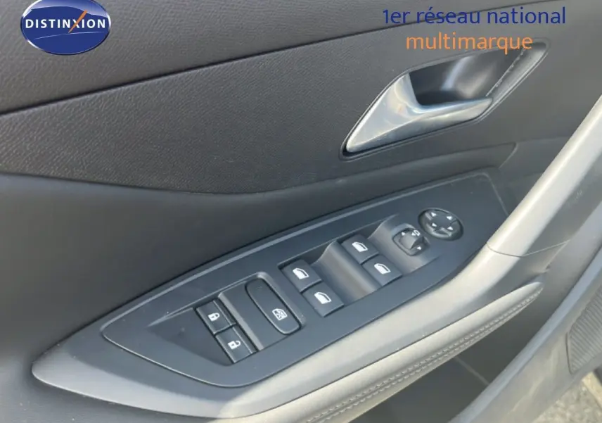 Vue rapprochée de la commande des vitres côté gauche sur porte intérieure noire d’une Peugeot 308 Hybrid 2025.