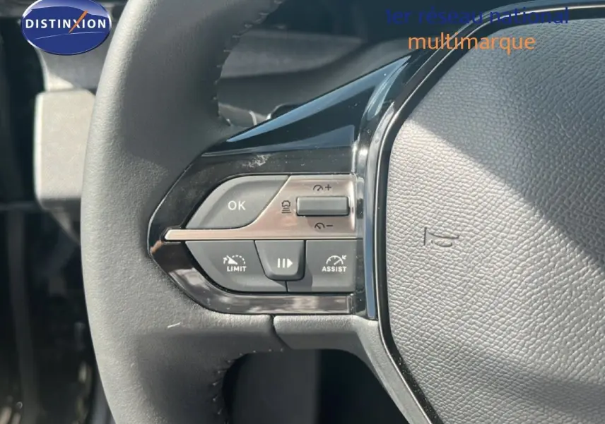 Gros plan sur le volant noir de la Peugeot 308 Hybrid 2025, montrant les commandes de régulateur de vitesse et d'assistance.