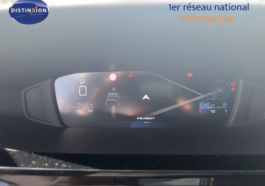 Tableau de bord numérique de Peugeot 308 Hybrid 145ch, affichant vitesse, autonomie et aides à la conduite.