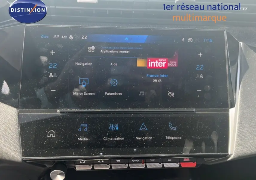 Écran tactile central de la Peugeot 308 Hybrid 145ch Allure 2025, affichant navigation et climatisation, intérieur noir.