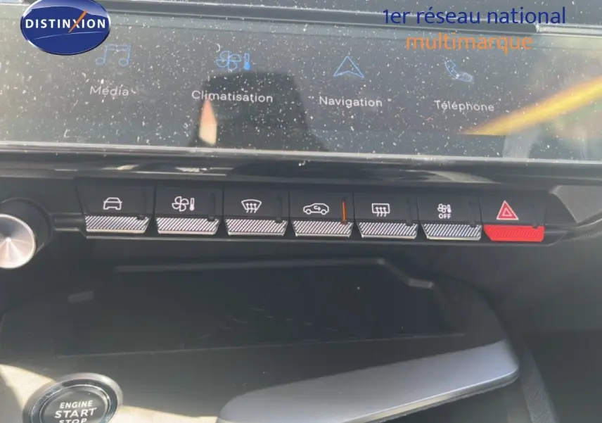 Vue rapprochée de la console centrale de la Peugeot 308 Hybrid 2025, avec boutons de climatisation et écran tactile.