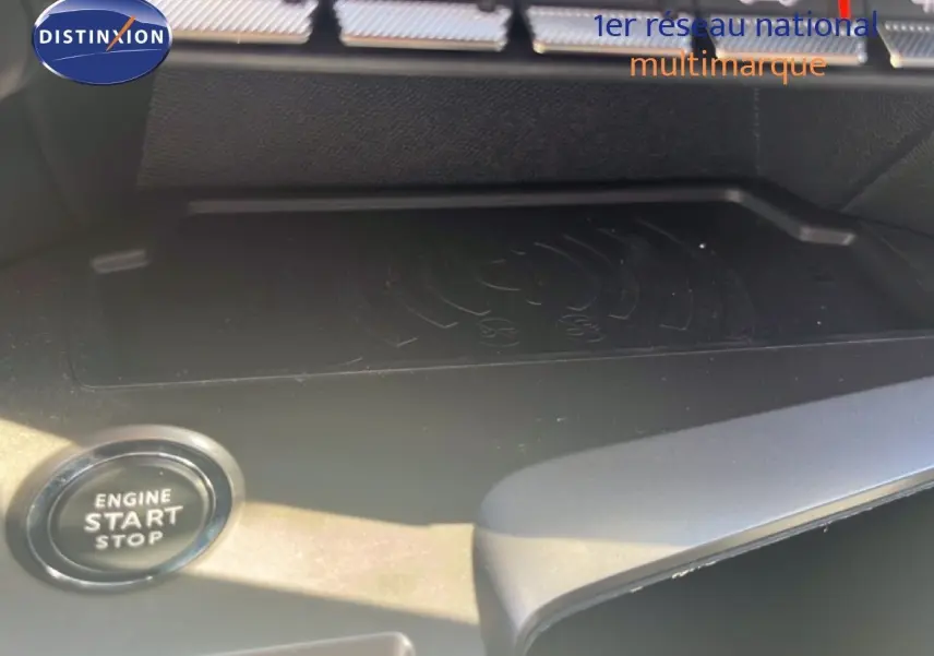 Détail intérieur du bouton start/stop et zone de recharge sans fil sur la console centrale d’une Peugeot 308 noire.