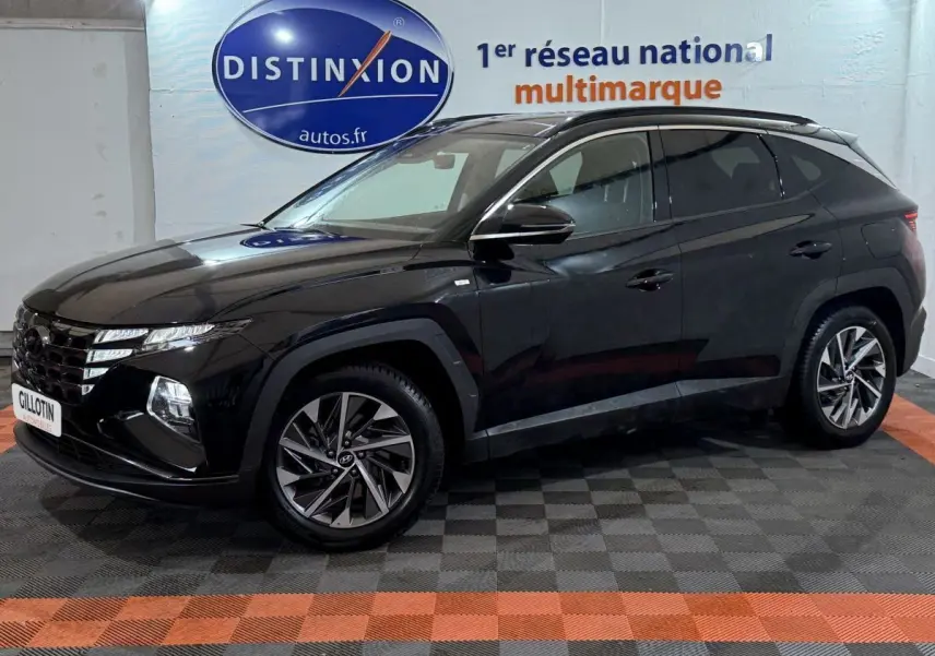 Hyundai Tucson noir en 3/4 avant droit, avec jantes alliage et calandre distinctive sous un panneau Distinxion.