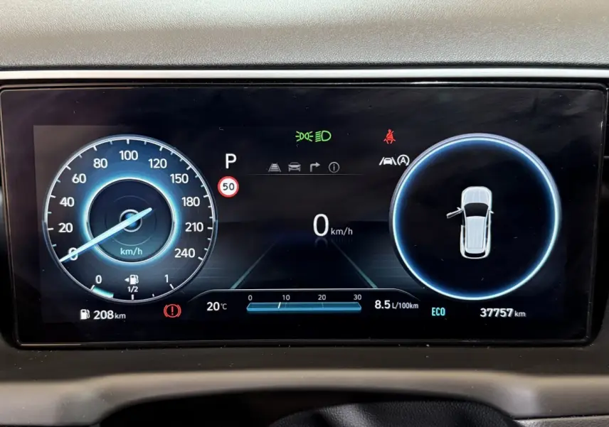 Affichage numérique du tableau de bord du Hyundai Tucson hybride 2021 montrant vitesse, consommation et alertes.