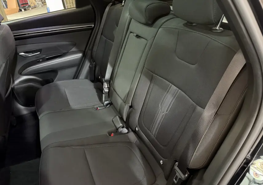 Vue intérieure des sièges arrière noirs du Hyundai Tucson 2021, avec ceinture de sécurité et garniture tissu.
