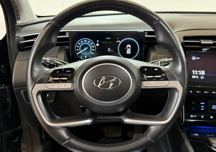 Vue rapprochée du volant cuir et alu du Hyundai Tucson 2021 avec tableau de bord numérique et écran tactile central.