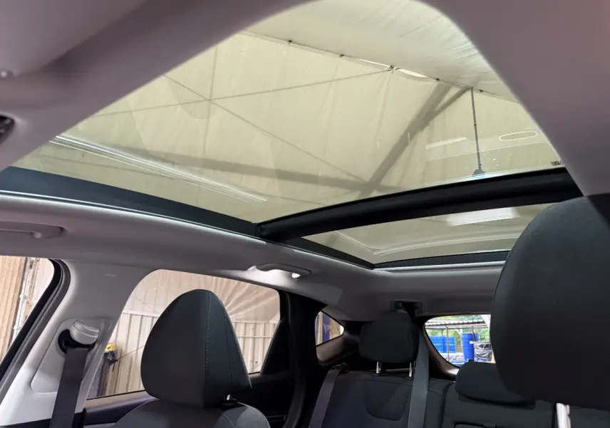 Vue intérieure arrière du Hyundai Tucson noir 2021 avec toit panoramique et sièges tissu gris foncé.