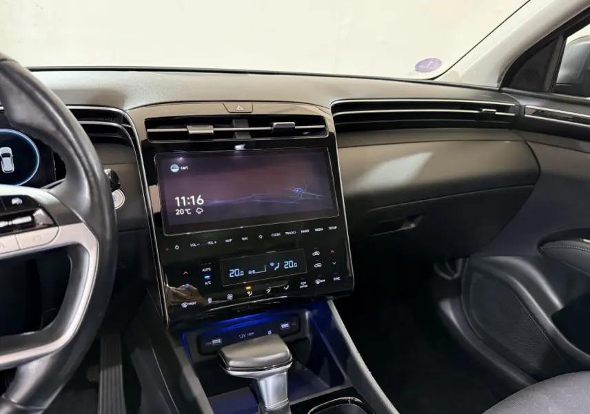 Vue intérieure du tableau de bord et console centrale du Hyundai Tucson noir, avec écran tactile et commandes digitales.