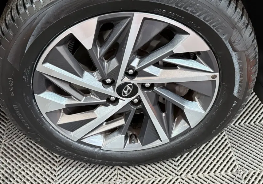 Gros plan sur la jante alliage argentée du Hyundai Tucson noir 2021, mettant en valeur le logo Hyundai central.
