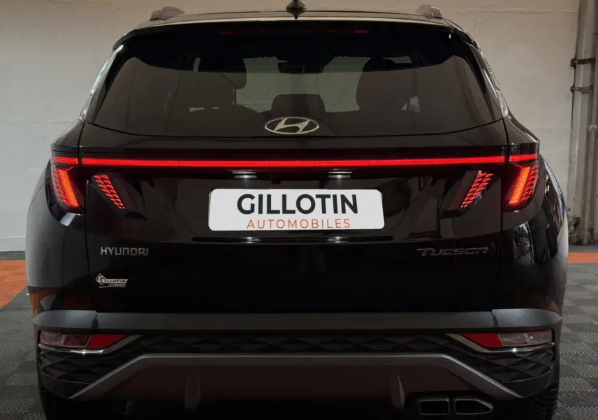 Vue arrière d'un Hyundai Tucson noir avec feux LED en bandeau et double sortie d'échappement rectangulaire.