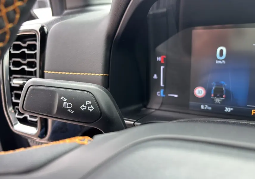 Détail intérieur du Ford Ranger 2025 Wildtrak Plus, montrant la commande de clignotants et le tableau de bord numérique.