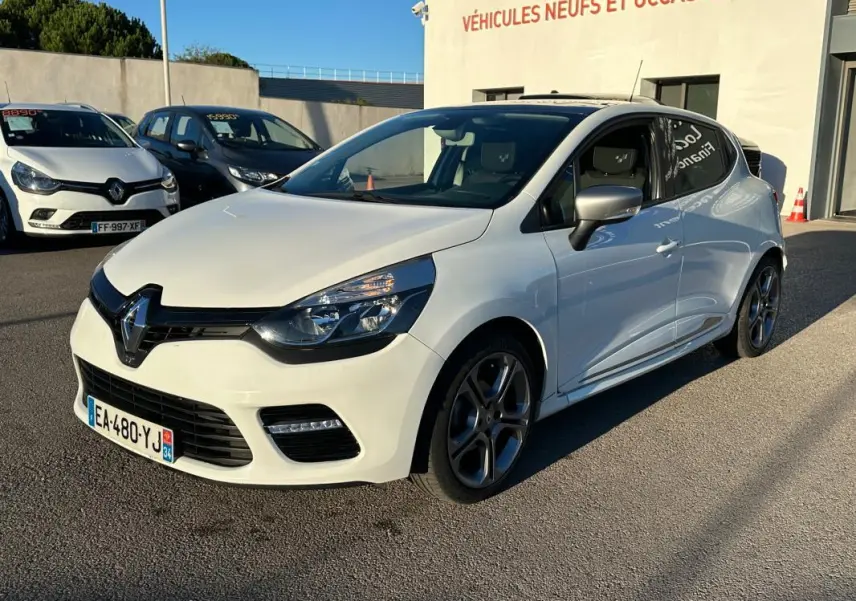 Renault Clio IV TCe 120 GT blanc vue 3/4 avant droit, jantes alliage 17 pouces et vitres surteintées visibles.