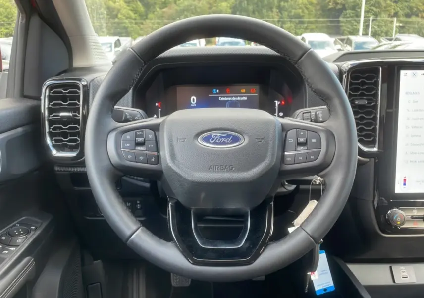 Intérieur du Ford Ranger 2025, vue centrée sur le volant multifonction et le tableau de bord numérique.