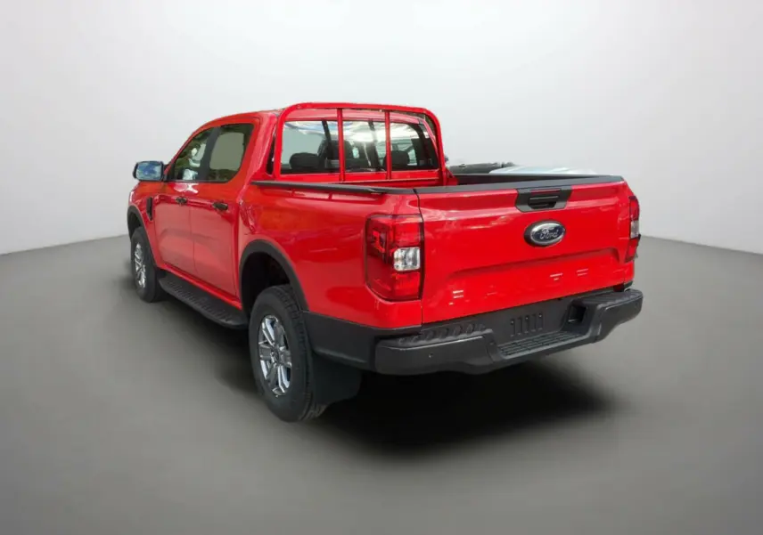 Ford Ranger rouge racing en 3/4 arrière droit, avec benne et protection de cabine visibles dans un studio lumineux.