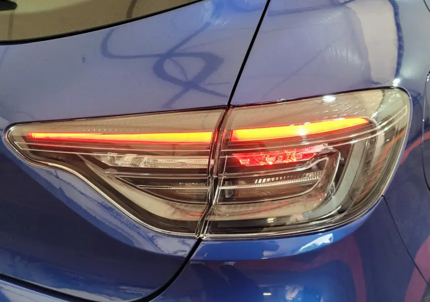 Feu arrière droit allumé sur Renault Clio bleu Evolution Blue dCi 100 de 2025, vue rapprochée du coffre et aile arrière.