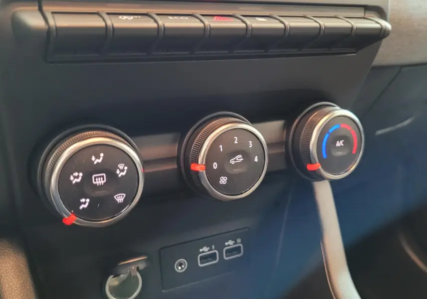 Gros plan sur les commandes de climatisation et ports USB de la Renault Clio Evolution Blue dCi 100, intérieur noir.