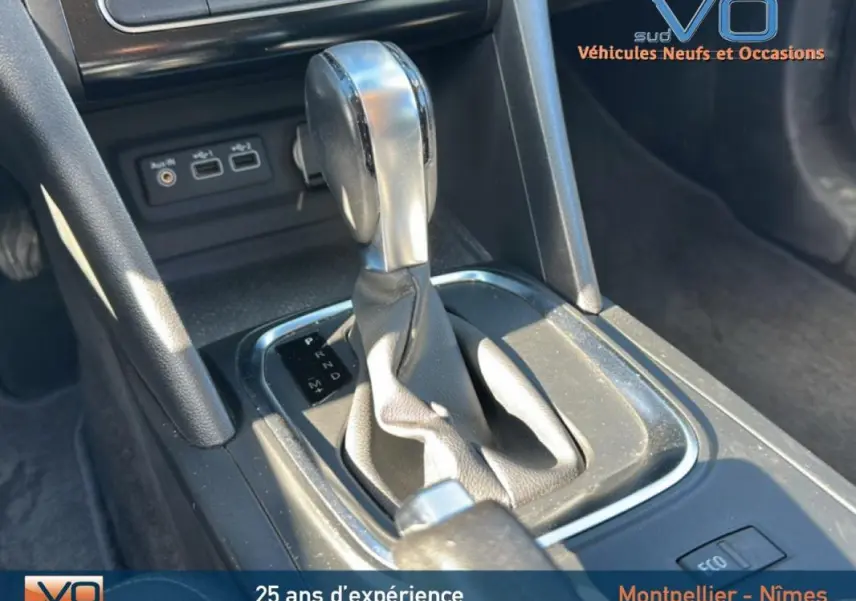 Gros plan sur la console centrale de la Renault Mégane IV gris clair, avec levier de boîte automatique et commandes USB visibles.