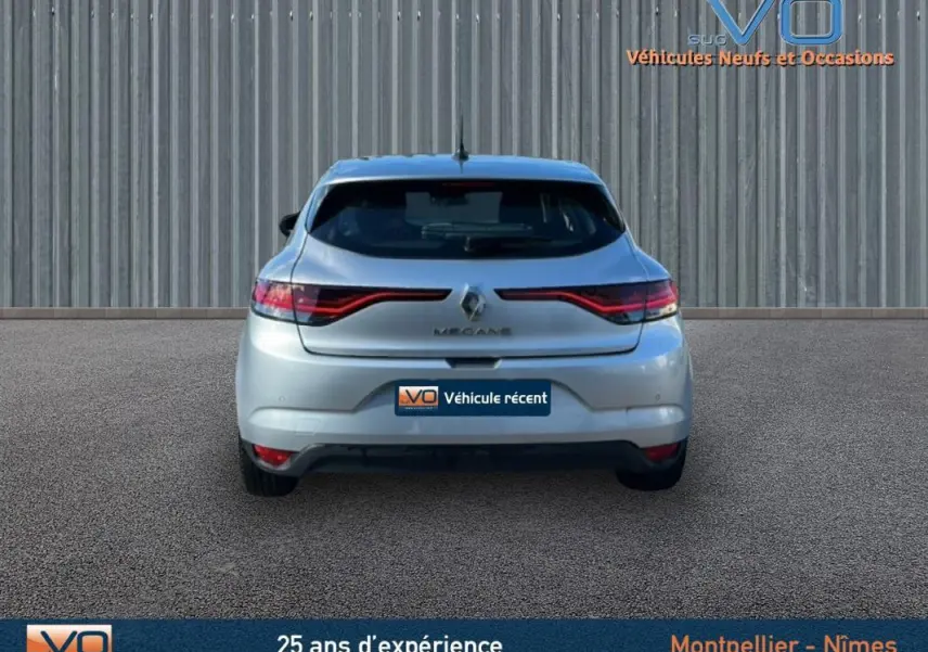 Vue arrière d'une Renault Mégane IV Berline gris clair de 2022, avec feux arrière LED et logo central visible.
