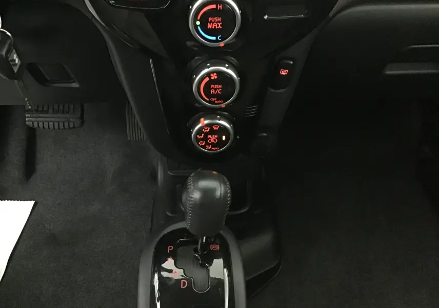 Gros plan sur la console centrale de la Citroën C-ZERO gris alu 2018, avec levier de boîte auto et commandes climatisation éclairées.
