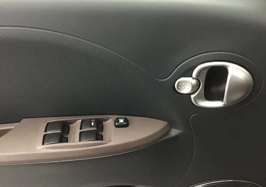 Poignée intérieure et commandes des vitres côté gauche de la porte d'une Citroën C-ZERO gris alu, version Confort 2018.