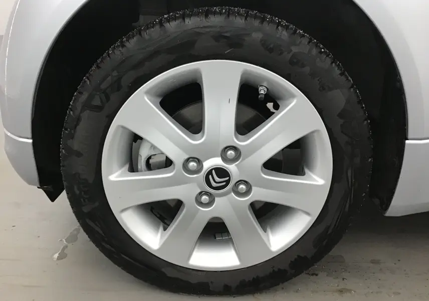 Gros plan sur la roue avant gauche grise alu d'une Citroën C-ZERO électrique 2018 avec jante en alliage et logo Citroën central.