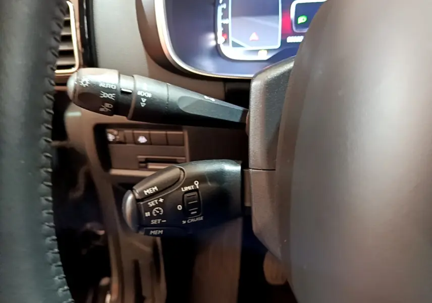 Gros plan sur les commandes au volant noir et le combiné numérique du tableau de bord du Citroën C5 Aircross gris foncé 2020.