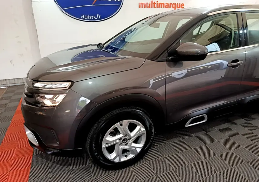 Vue 3/4 avant gauche d'un Citroën C5 Aircross gris foncé avec jantes alliage et inserts Silver Anodisé sur les Airbump.