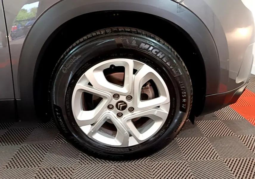 Gros plan sur la roue avant gauche du Citroën C5 Aircross gris foncé avec jante alliage 17 pouces Ellipse.