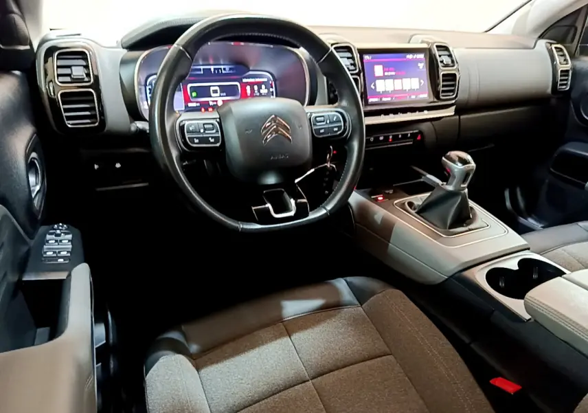 Vue intérieure côté conducteur du Citroën C5 Aircross 2020, volant cuir, combiné numérique et levier de vitesse manuel.