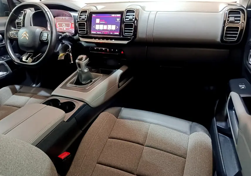 Intérieur du Citroën C5 Aircross 2020, vue du poste de conduite avec volant cuir et console centrale beige et noire.