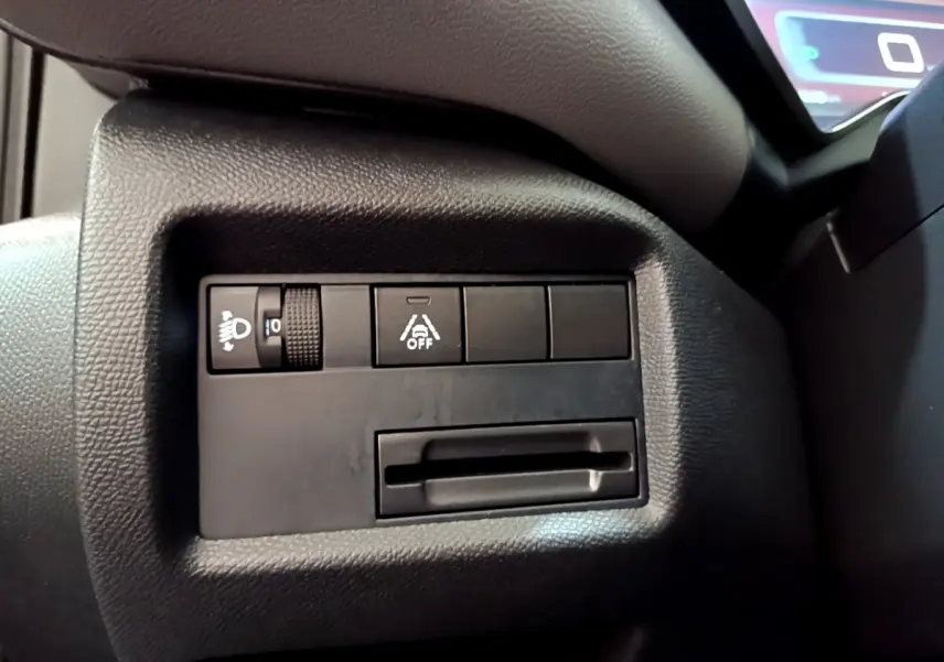 Gros plan sur les commandes de réglage des phares et de l'aide à la conduite dans le tableau de bord noir du Citroën C5 Aircross 2020.