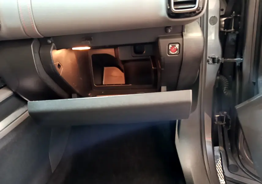 Intérieur côté passager du Citroën C5 Aircross gris foncé, boîte à gants ouverte avec éclairage intérieur visible.