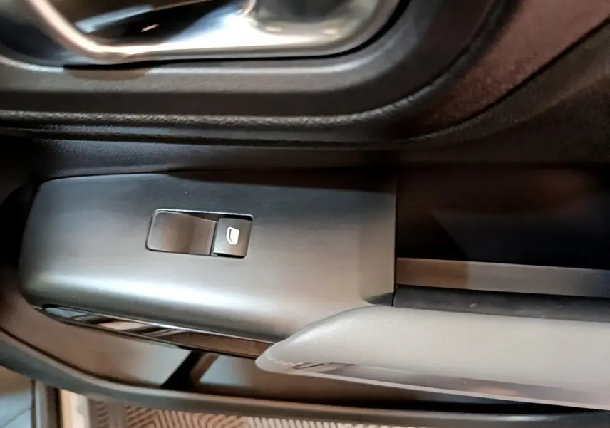 Détail de la commande de lève-vitre électrique côté conducteur dans l'habitacle gris foncé du Citroën C5 Aircross 2020.