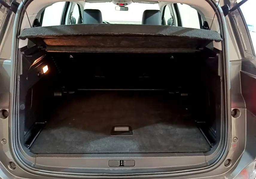 Coffre ouvert vu de l'arrière d'un Citroën C5 Aircross gris foncé, montrant l'espace de chargement et la tablette cache-bagages.