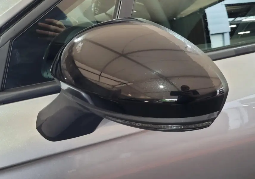 Rétroviseur extérieur droit noir brillant avec clignotant intégré sur Renault Clio gris foncé 2025, vue rapprochée.