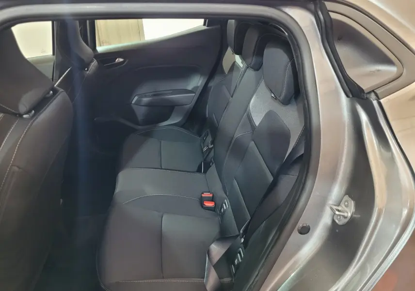 Vue intérieure sur la banquette arrière noire de la Renault Clio gris foncé, porte arrière droite ouverte.