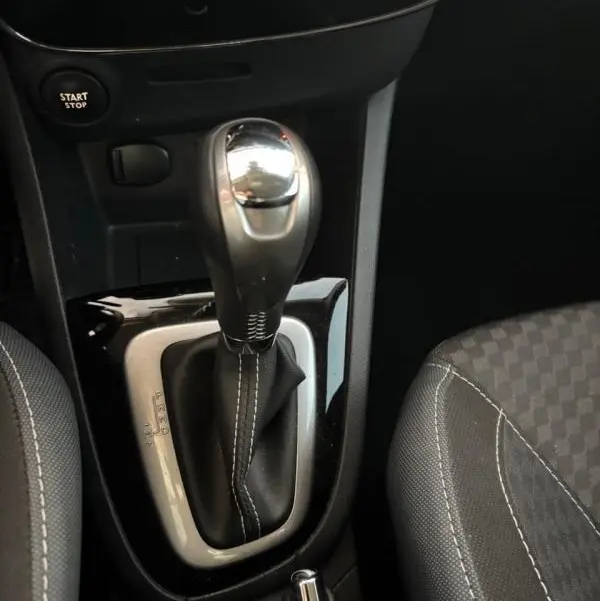 Le levier de vitesse automatique et la console centrale de la Renault Clio IV Estate TCe 120 GT EDC, avec sellerie noire à surpiqûres blanches.