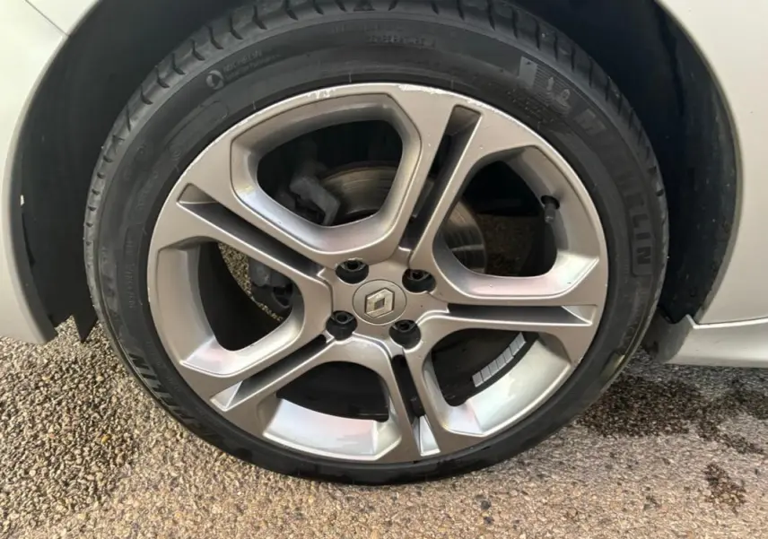 Gros plan sur la jante alliage 17 pouces grise claire d'une Renault Clio IV Estate TCe 120 GT EDC, avec logo Renault central.