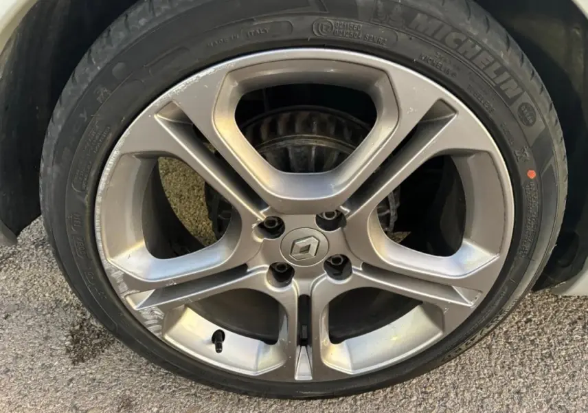 Gros plan sur la jante alliage 17 pouces gris clair d'une Renault Clio IV Estate TCe 120 GT EDC avec logo central.