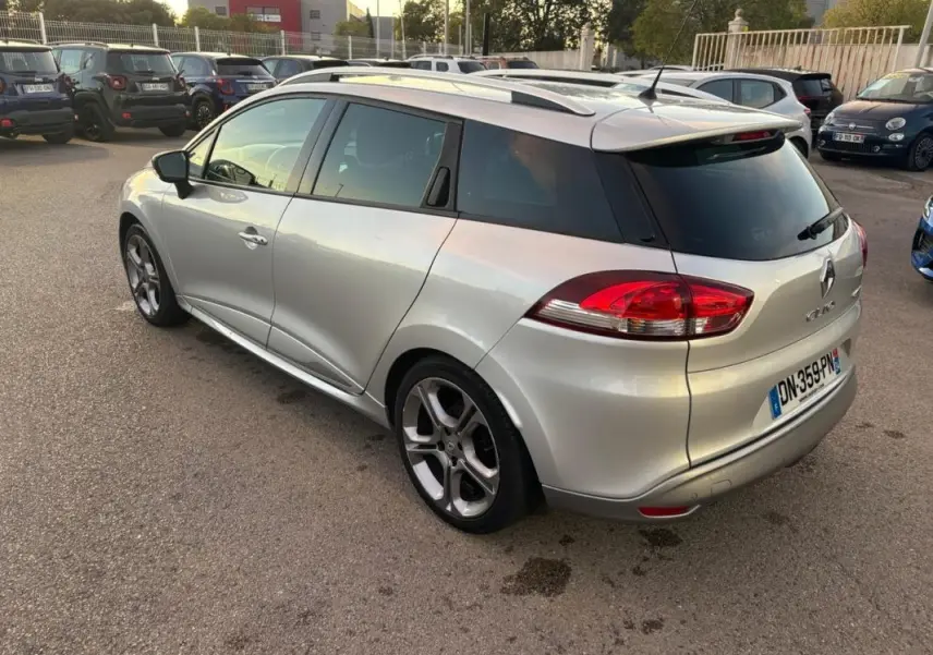 Vue 3/4 arrière droite d'une Renault Clio IV Estate gris clair avec jantes alliage 17 pouces et vitres surteintées.