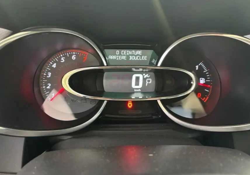 Tableau de bord numérique de Renault Clio IV Estate gris clair, affichant vitesse à 0 km/h et alertes ceinture arrière.