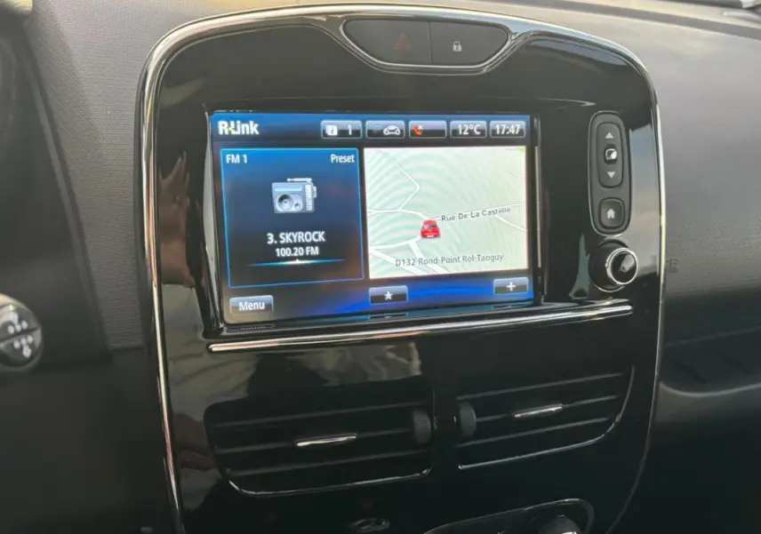 Écran tactile central R-Link avec navigation et radio, tableau de bord noir brillant de Renault Clio IV Estate gris clair.