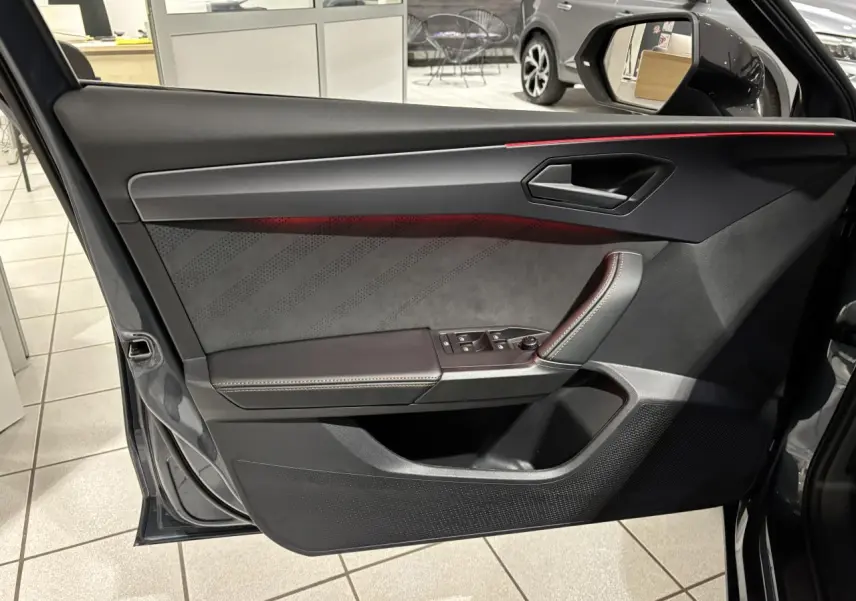 Vue intérieure côté gauche de la porte avant gris graphène avec éclairage d'ambiance cuivré et garniture suédine noire.